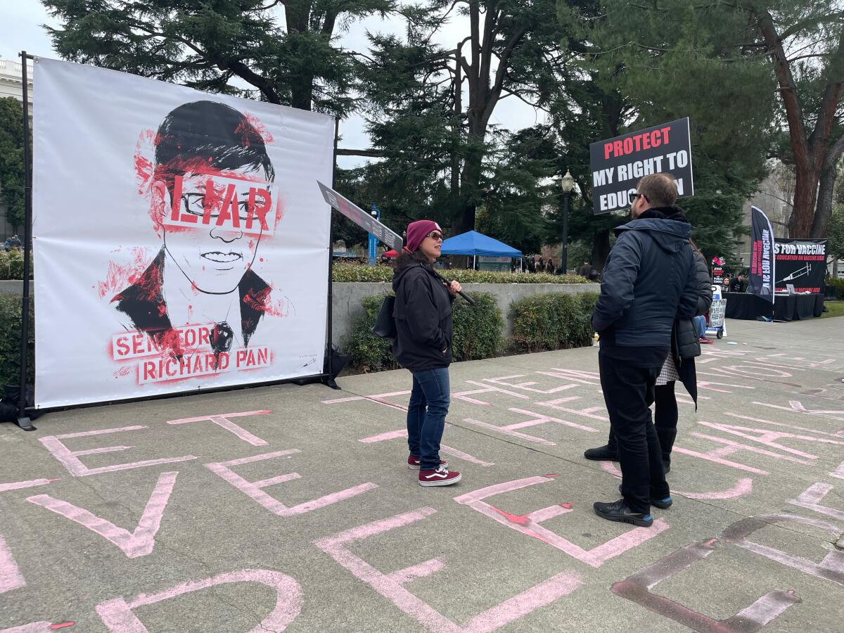 People target state Sen. Richard Pan with a sign showing an illustration of his face with the word 'Liar' over it