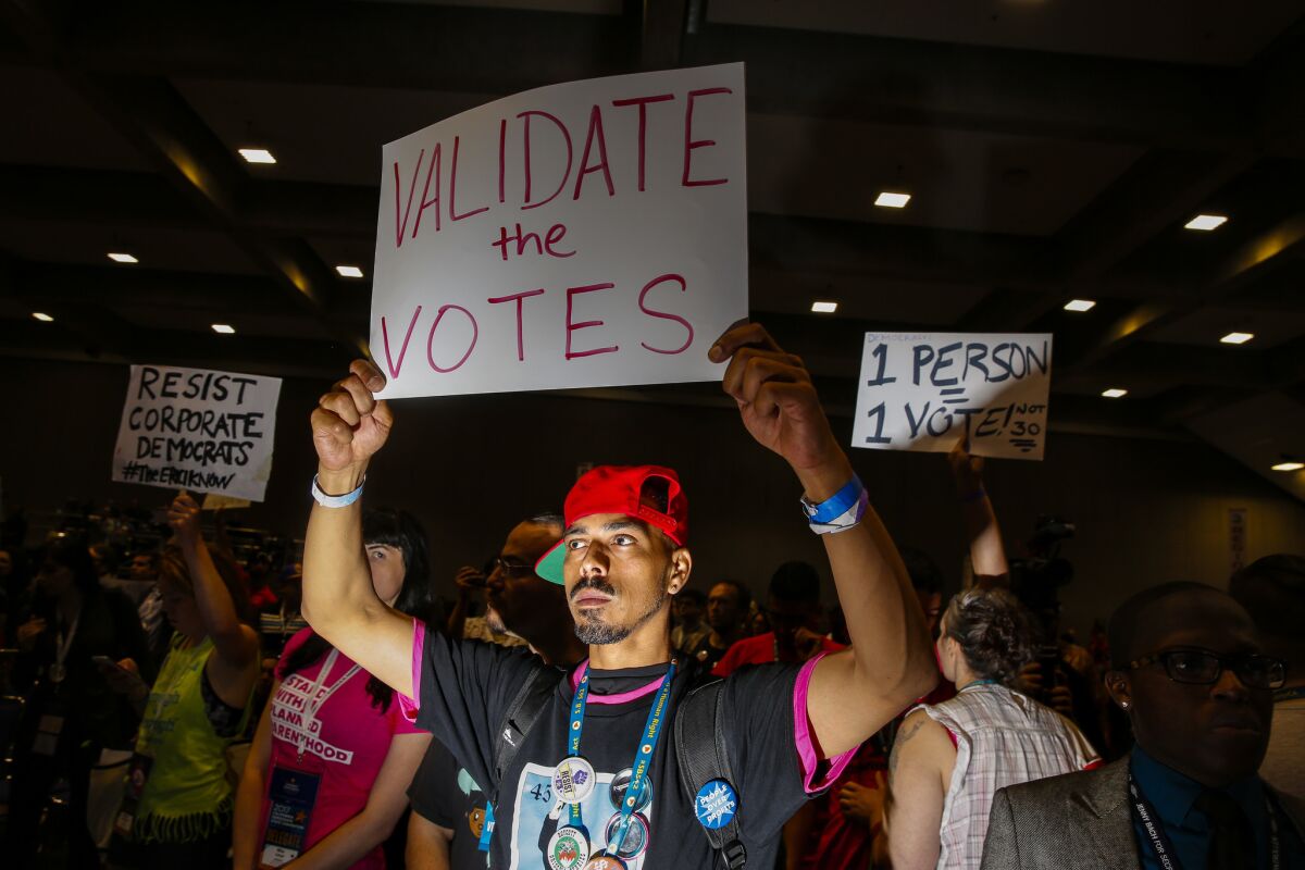 Gilbert Feliciano, center, and other delegates supporting Kimberly Ellis chant for an opportunity to speak during a contentious moment discussing the election results for California Democratic Party chairperson on the final day of the party's state convention.