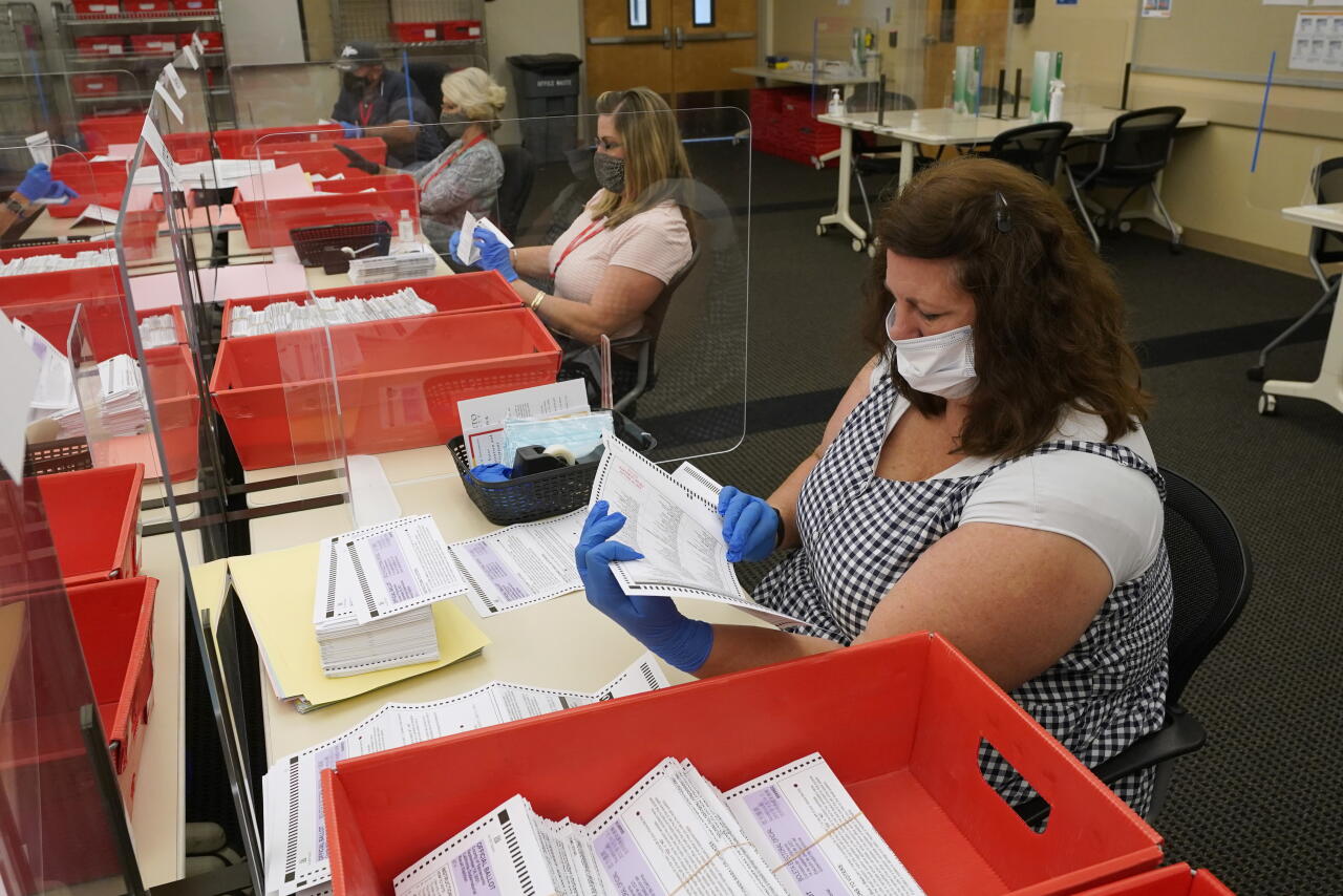 Election workers inspect ballots at the Sacramento County Registrar of Voters office in Sacramento, Calif., Aug. 30, 2021.
