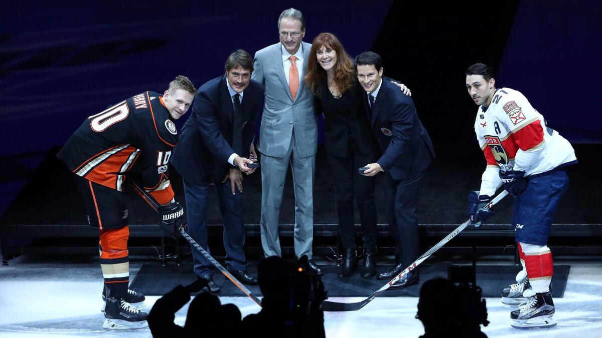 Corey Perry of the Ducks, former Duck Teemu Selanne, Ducks owners Henry and Susan Samueli, former Duck Paul Kariya and Vincent Trocheck of the Florida Panthers pose for the ceremonial puck drop during a pregame ceremony at Honda Center.