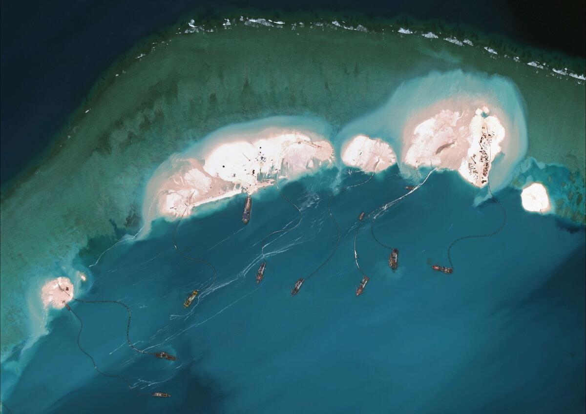 A satellite image posted on the website of the Center for Strategic and International Studies last week shows a flotilla of Chinese vessels in the South China Sea dredging sand onto Mischief Reef and the resulting land spreading in size.