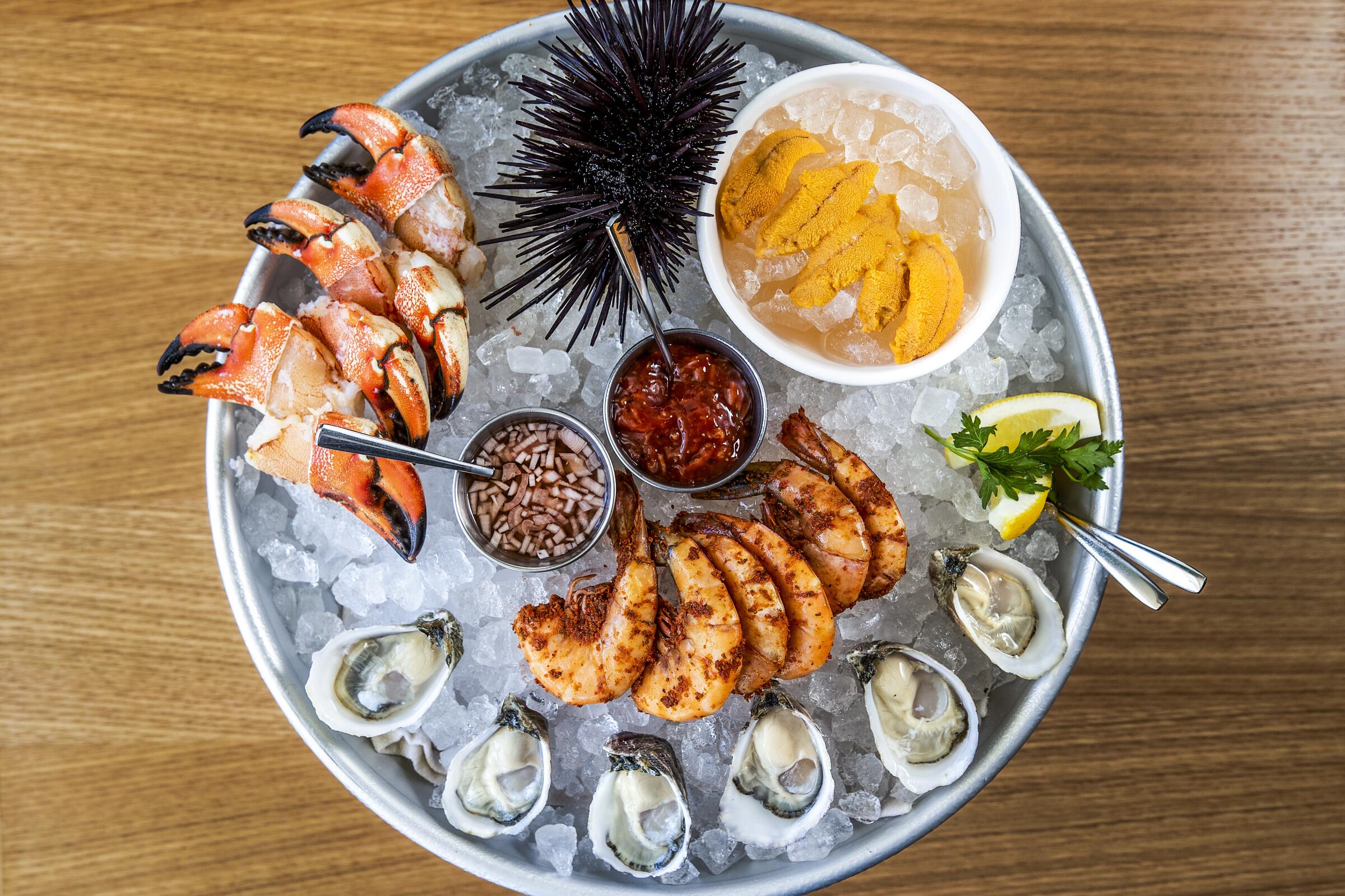 Jonah crab claws, Santa Barbara sea urchin, peel-and-eat shrimp and Pacific Gold Reserves oysters on ice.