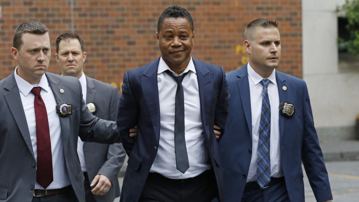 Actor Cuba Gooding Jr is led by police officers from the New York Police Department's special victims division on Thursday.