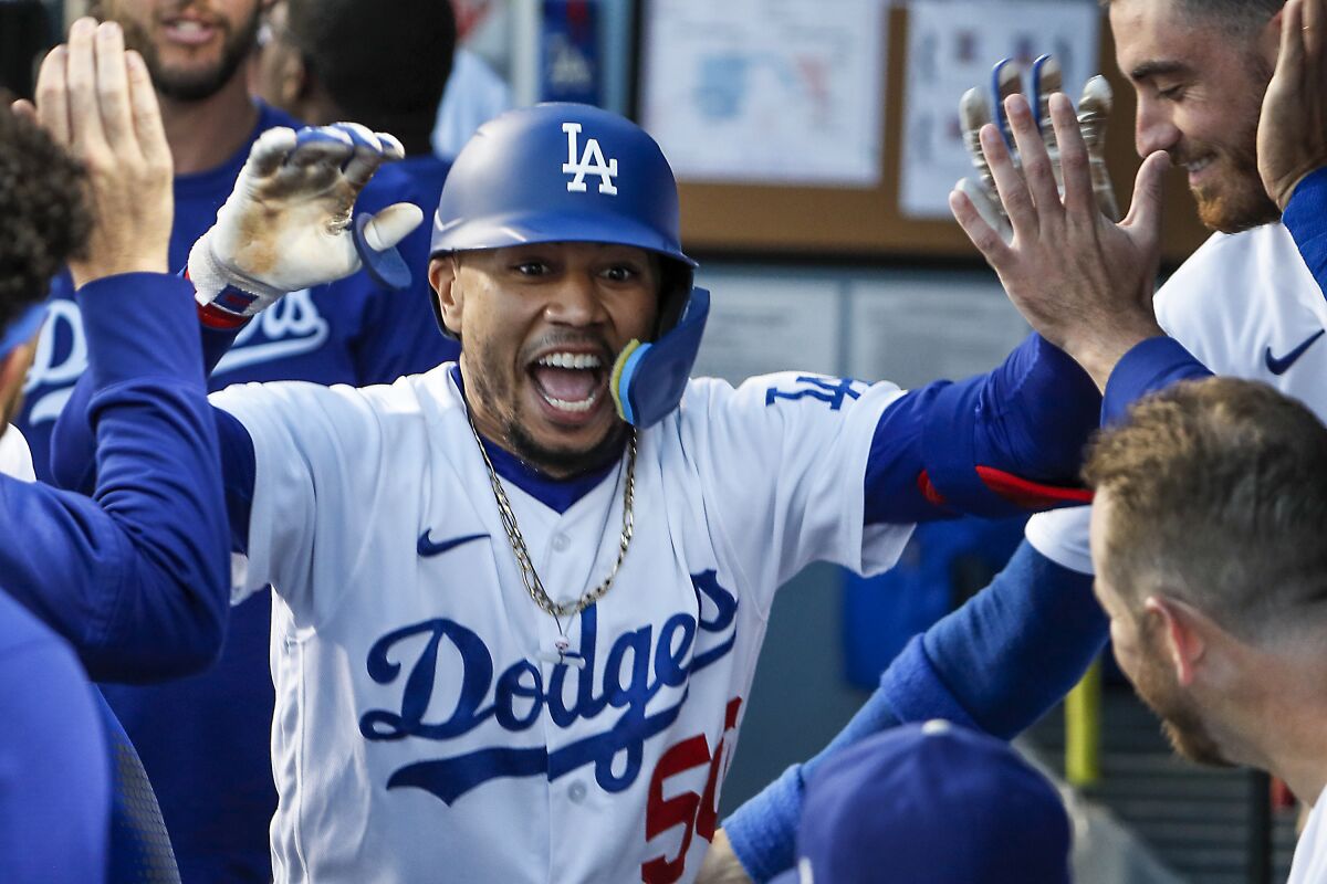 Dodgers right fielder Mookie Betts celebrates in the dugout after hitting a home run July 5 against the Colorado Rockies .