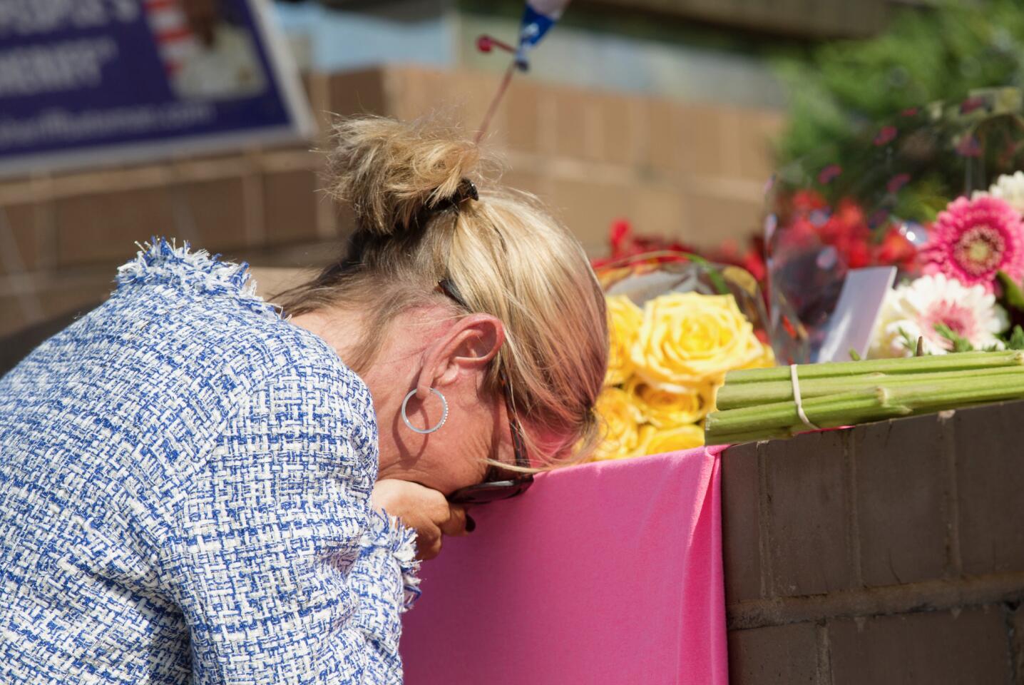 An unidentified mourner grieves at a small memorial set up at the entrance of 888 Bestgate Road on Friday, June 29, 2018. A gunman blasted his way into the Capital Gazette newsroom in Annapolis with a shotgun Thursday afternoon, killing five people and injuring two others, authorities said.