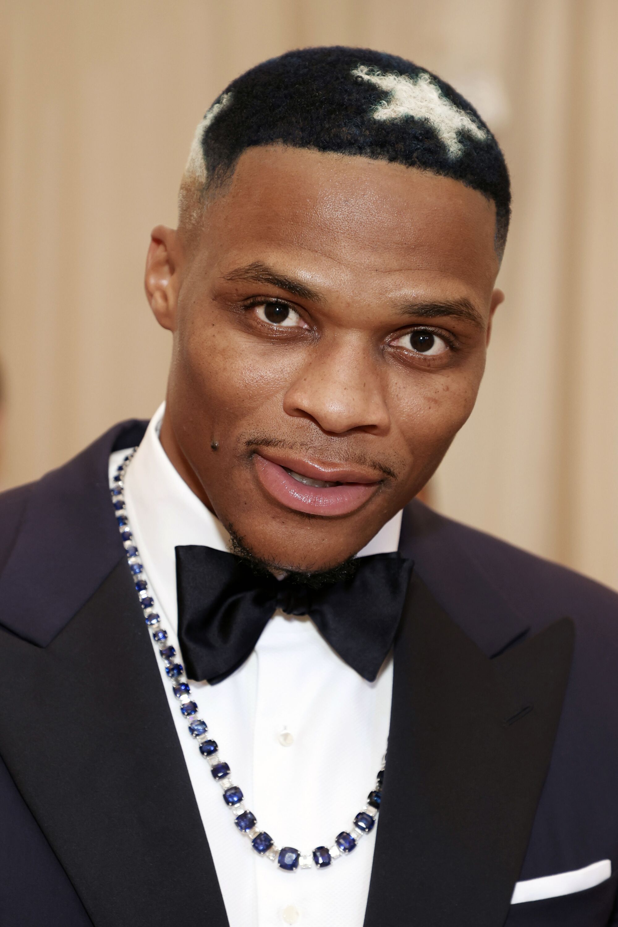 A man in a tuxedo with a star dyed into his hair