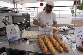 El panadero francés Tony Dore prepara baguettes como las que les ofrecerán a los deportistas durante los Juegos Olímpicos de París el martes 30 de abril del 2024. (AP Foto/Michel Euler)