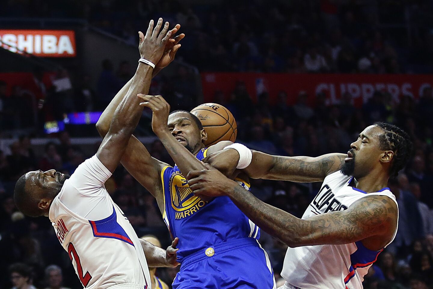 Warriors forward Kevin Durant is fouled by Clippers center DeAndre Jordan, right, after driving down the lane against guard Raymond Felton (2) during the second half.