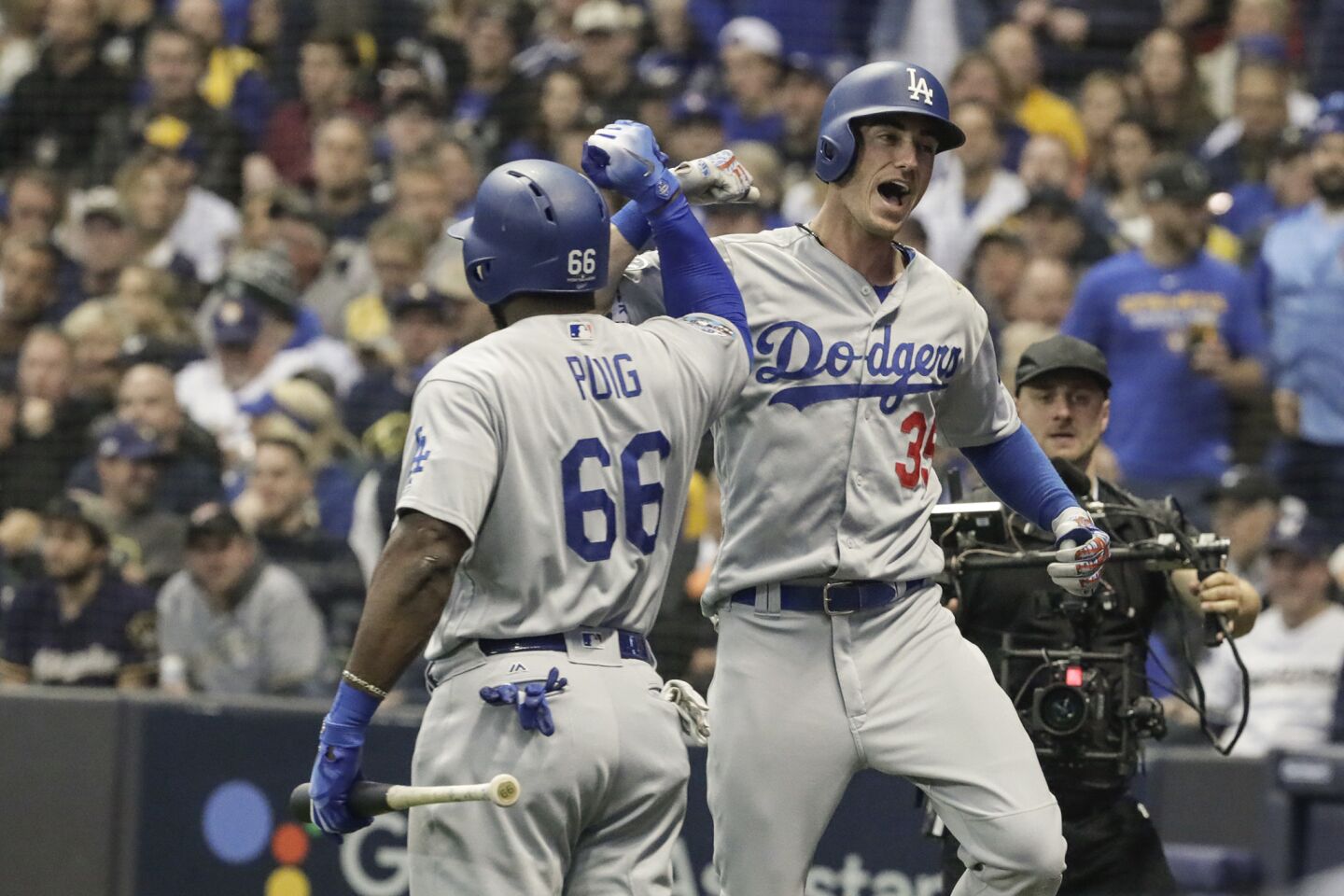Cody Bellinger celebrates with Yasiel Puig after hitting a second inning, two run homer.