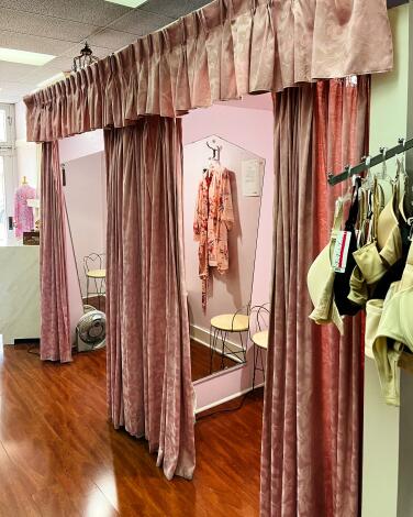 Pink curtains and pink walls accent dressing rooms at Laura's Corset Shoppe.