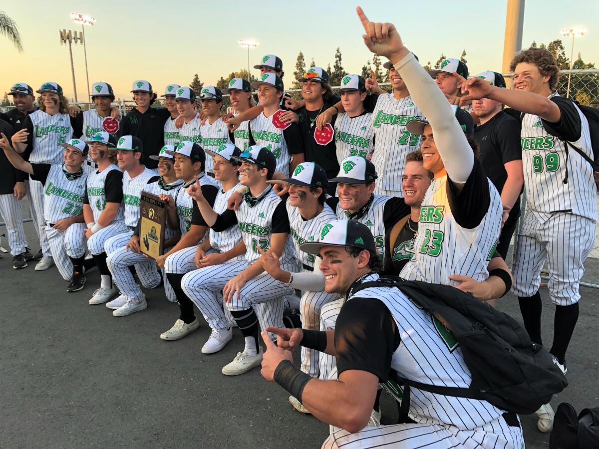 As the Lancers pose for a photo after winning the Division 2 title, Max Muncy (13) takes a seat on the knee of Roc Riggio.