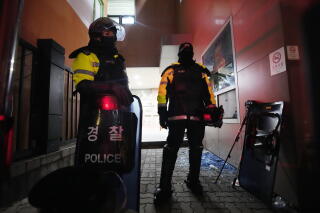 Police officers stand at the Seoul Western District Court after supporters of impeached.
