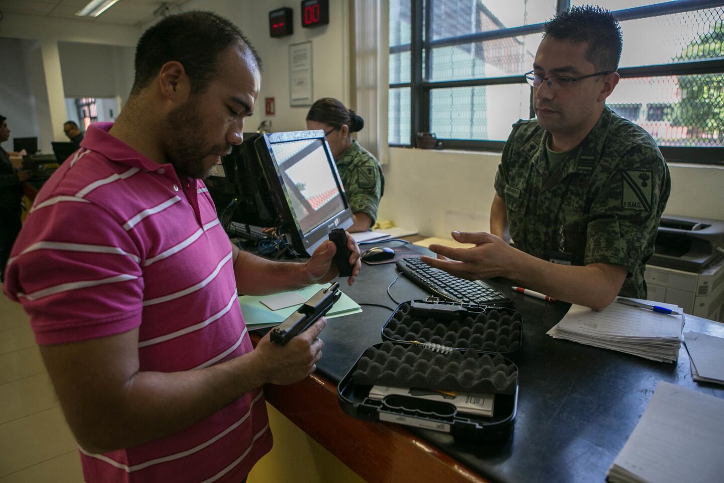 Hugo Joy Gallegos Sanchez, 32, of Mexico City examines a handgun at the Directorate of Arms and Munitions Sales, the only outlet for legal gun purchases in Mexico.