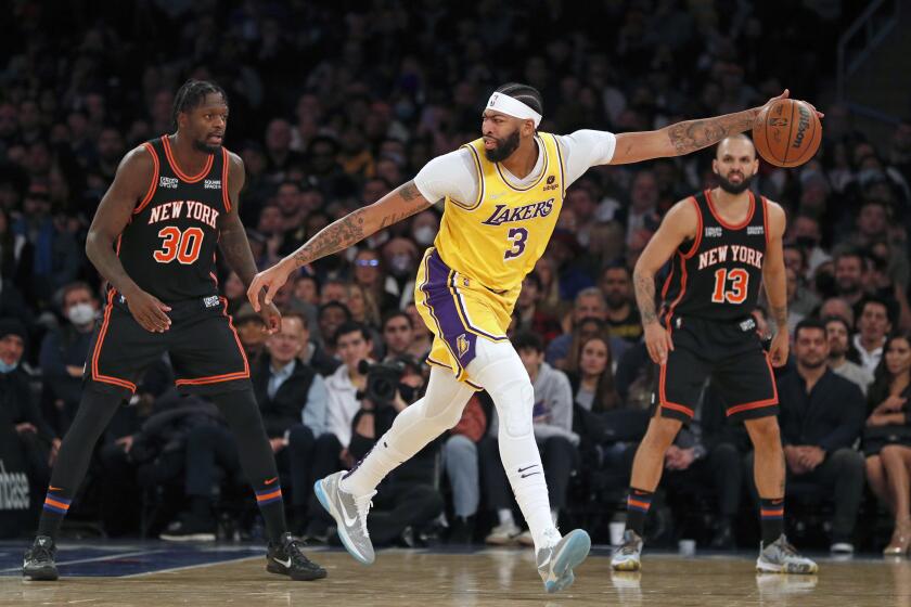 Los Angeles Lakers forward Anthony Davis (3) controls the ball during the second half of an NBA basketball game against New York Knicks forward Julius Randle (30) and guard Evan Fournier (13) on Tuesday, Nov. 23, 2021, in New York. (AP Photo/Jim McIsaac)