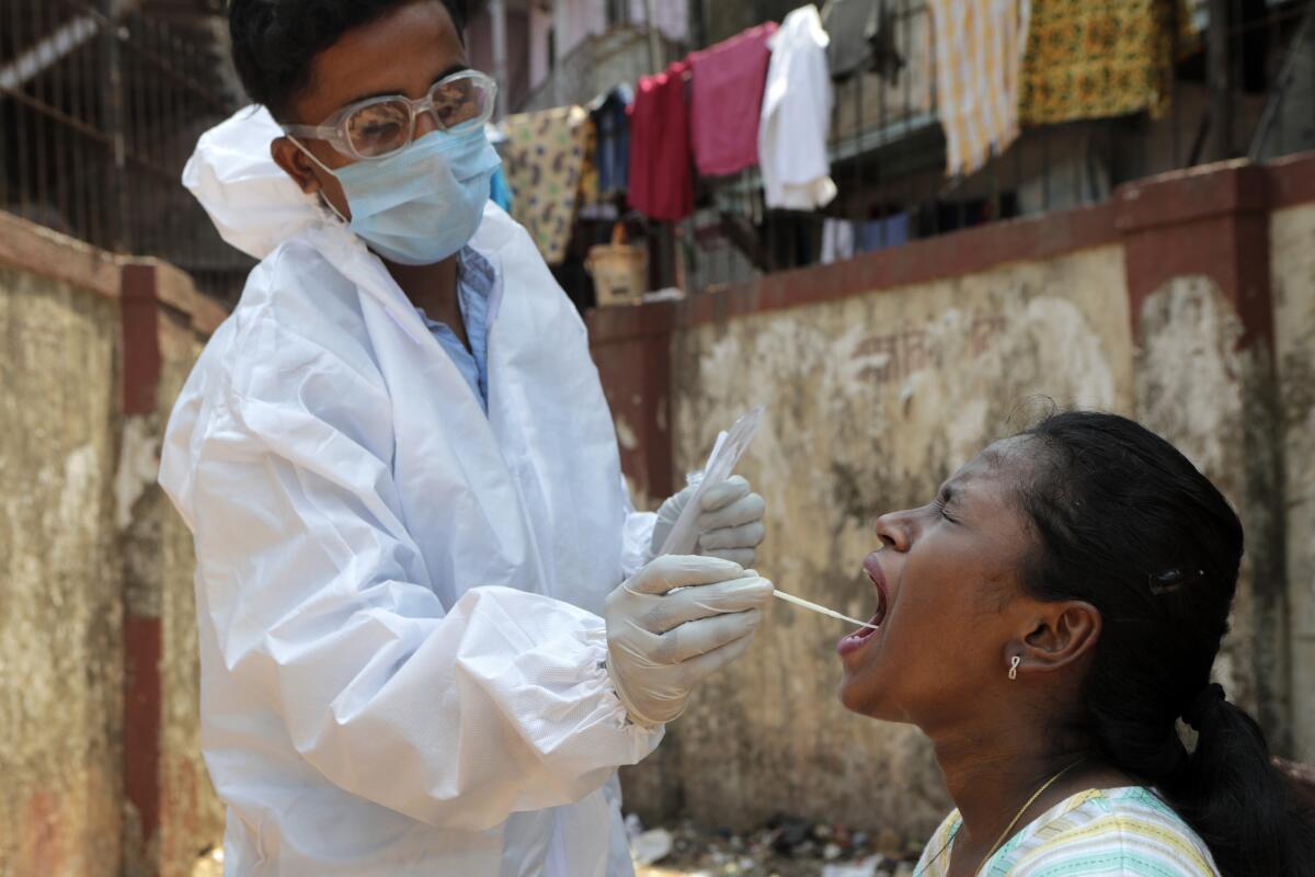 Un sanitario toma una muestra para una prueba de detección del coronavirus, en Dharavi.