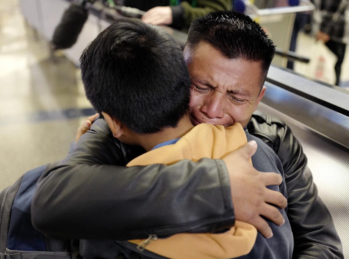 David Xol of Guatemala hugs his son Byron, 9, at Los Angeles International Airport