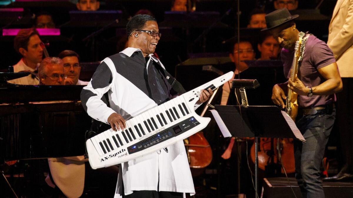 Oscar and Grammy Award-winning music legend Herbie Hancock is as accomplished performing on a guitar-like keytar (above) as he is on a grand piano, an electric piano or an array of state-of-the-art synthesizers. He is shown above at a 2018 Los Angeles concert with bassist Marcus Miller and the Gustavo Dudamel-led Los Angeles Philharmonic, whose jazz programming Hancock oversees.  