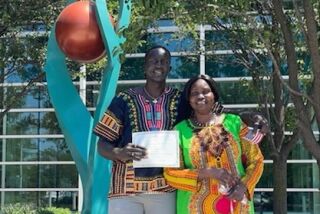 Aguek Arop and his mother pose for a photo outside the U.S. Department of Homeland Security in Omaha, Neb.