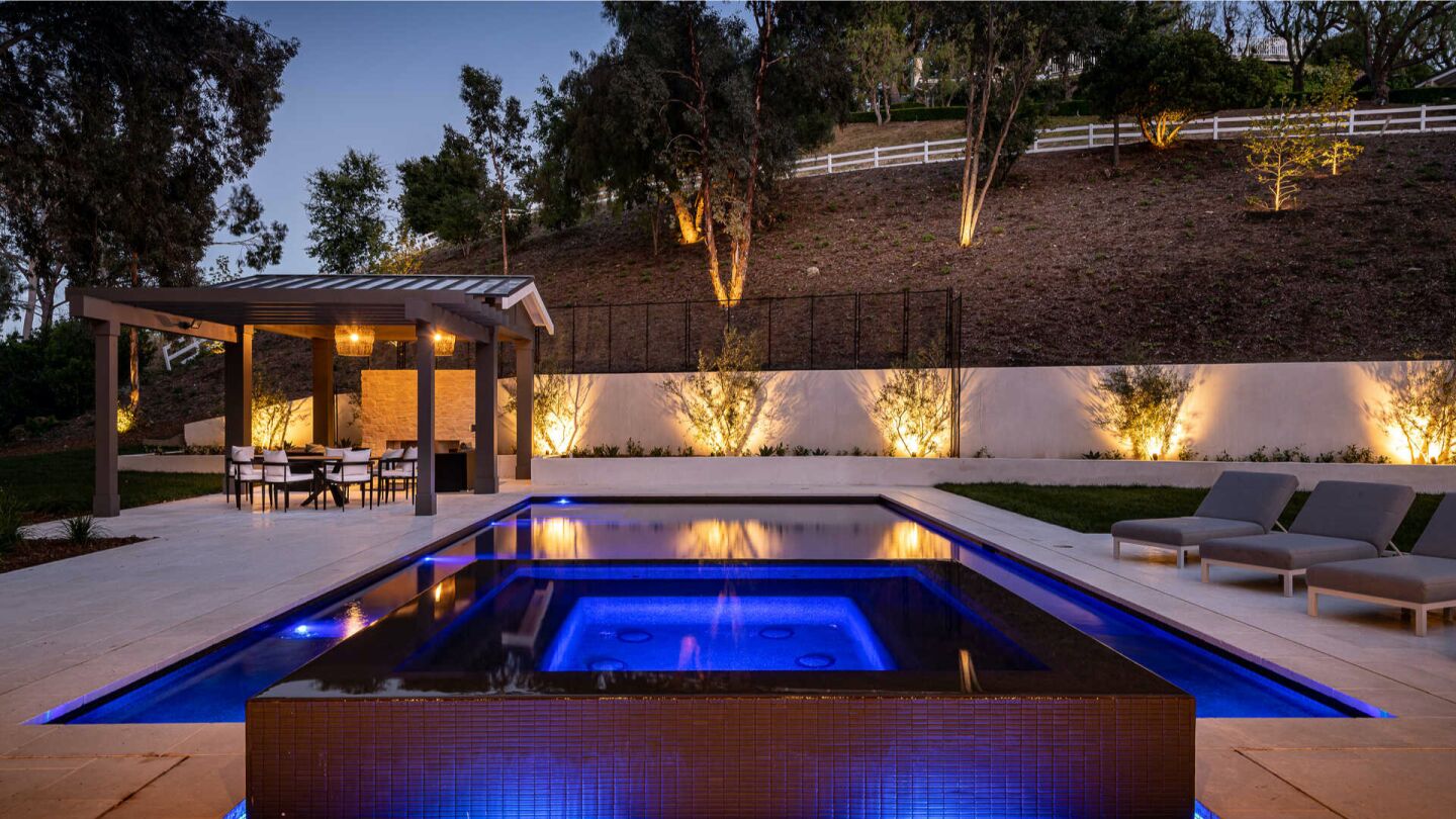 The black-tiled spa next to the pool.