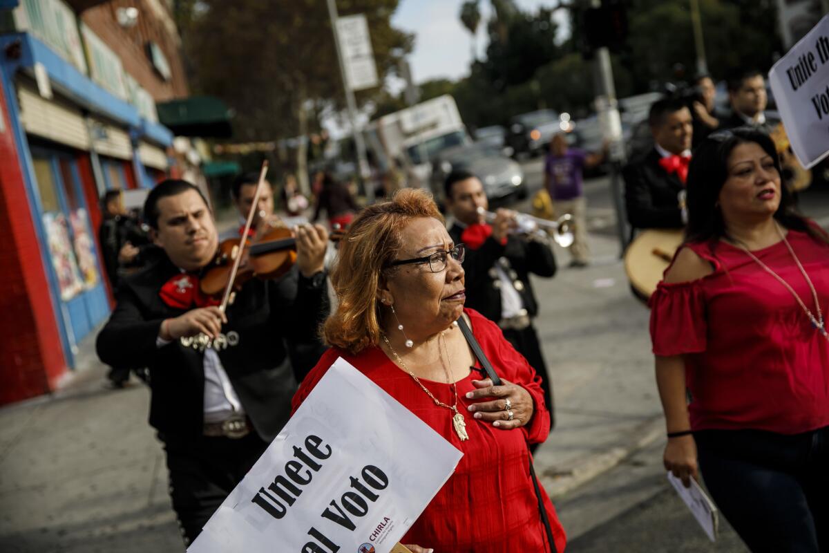 Griselda Sanchez walks to the polls to vote as she is followed by the Mariachi Cuicatlan, organized by CHIRLA (The Coalition for Humane Immigrant Rights Los Angeles) in an effort urge others to get out to vote by serenading them in Los Angeles.
