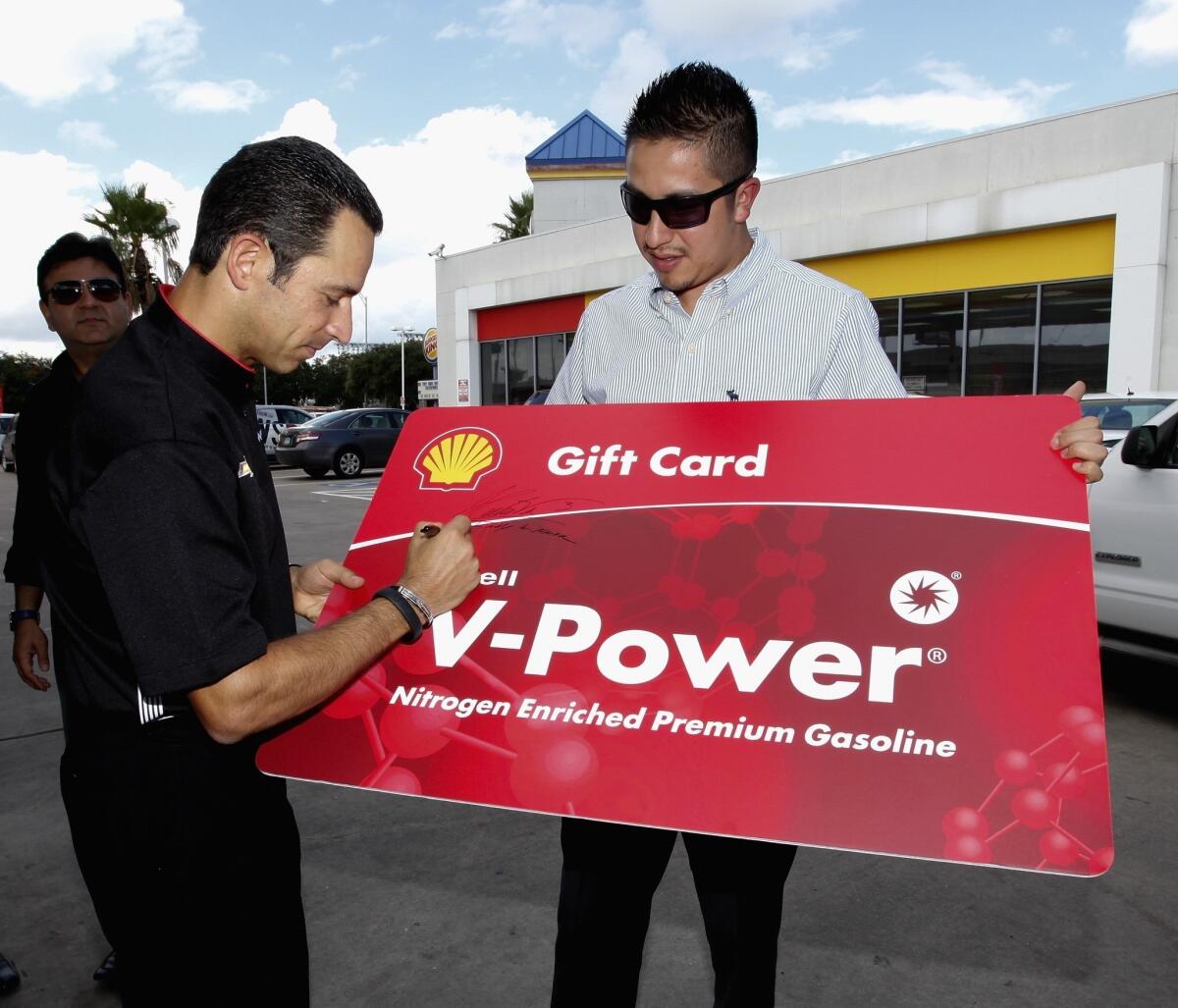 IndyCar driver Helio Castroneves surprises fans with free fuel and prizes during an event before the Grand Prix of Houston.