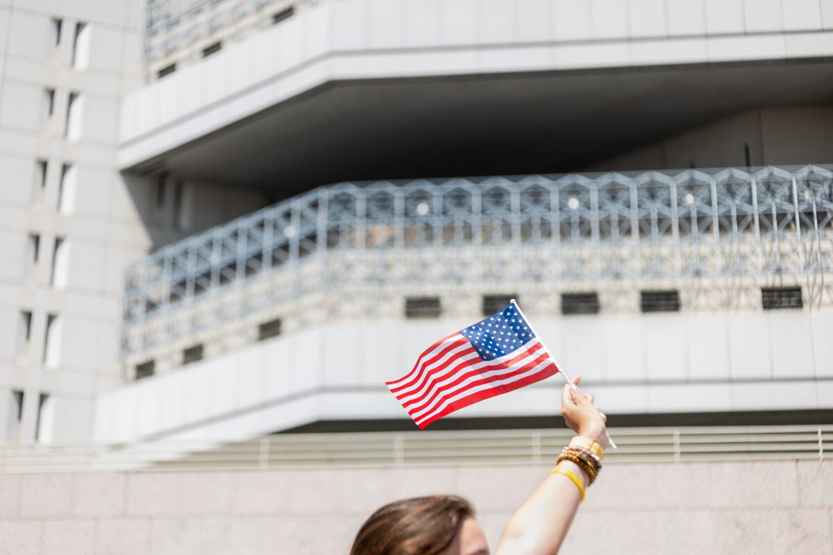 A man waving national flag while passing through the Metropolitan Detention Center