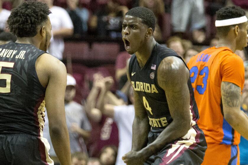 Florida State's Dwayne Bacon, Jr. (4) celebrates a basket with teammate PJ Savoy (5) in the first half of their game against Florida on Sunday.