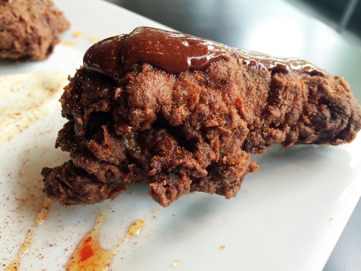Chocolate fried chicken with chocolate ketchup on top.