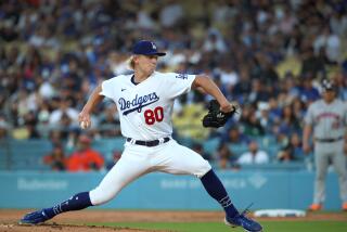 Dodgers starter Emmet Sheehan stretches on the mound and delivers a pitch.