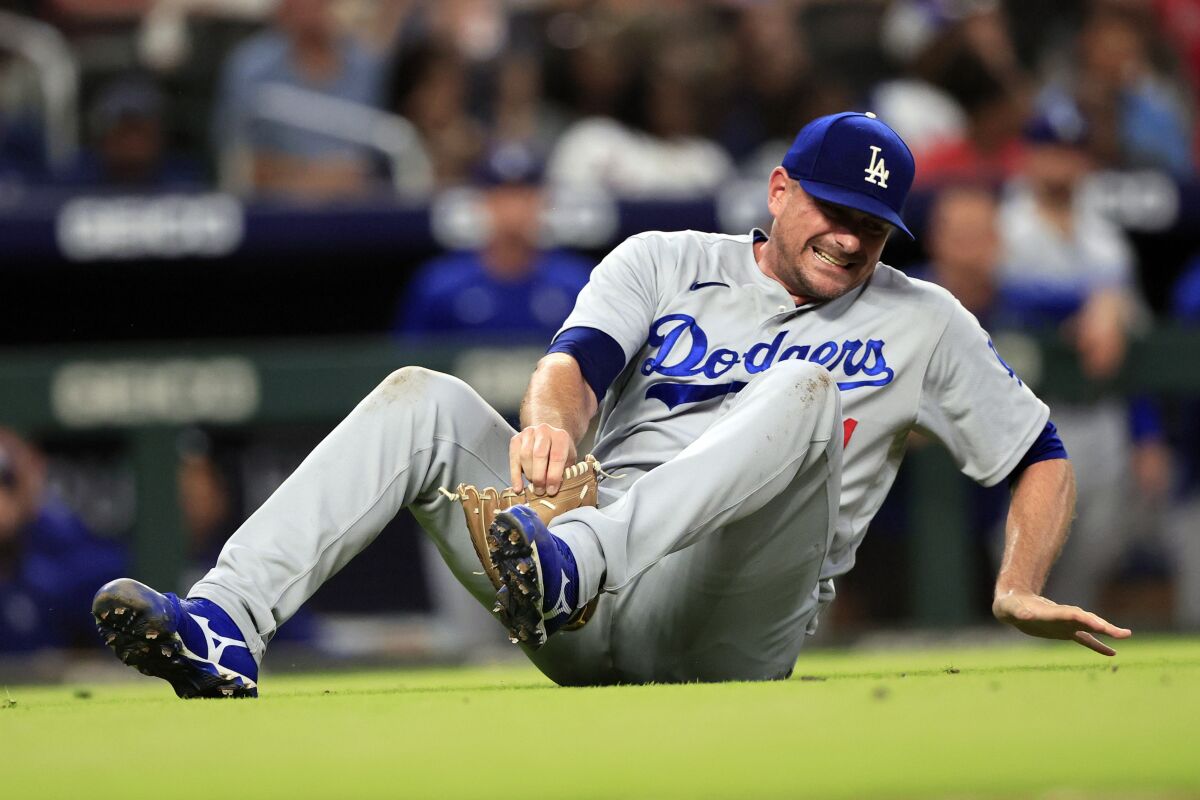 Dodgers substitute Daniel Hudson falls to the ground and winces after injuring his knee