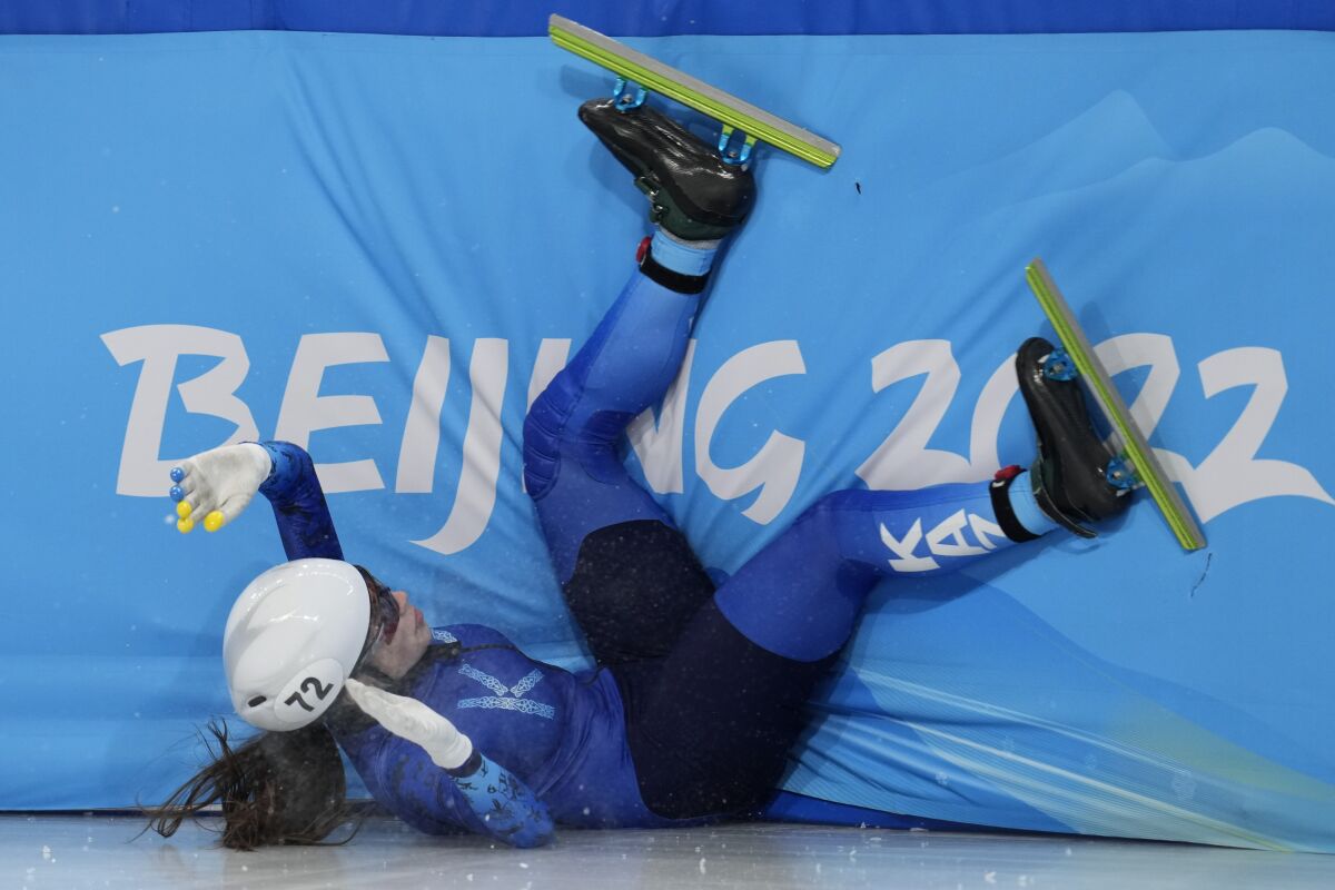 Olga Tikhonova of Kazakhstan, crashes in her heat of the women's 1000-meters during the short track speedskating competition at the 2022 Winter Olympics, Wednesday, Feb. 9, 2022, in Beijing. (AP Photo/Natacha Pisarenko)