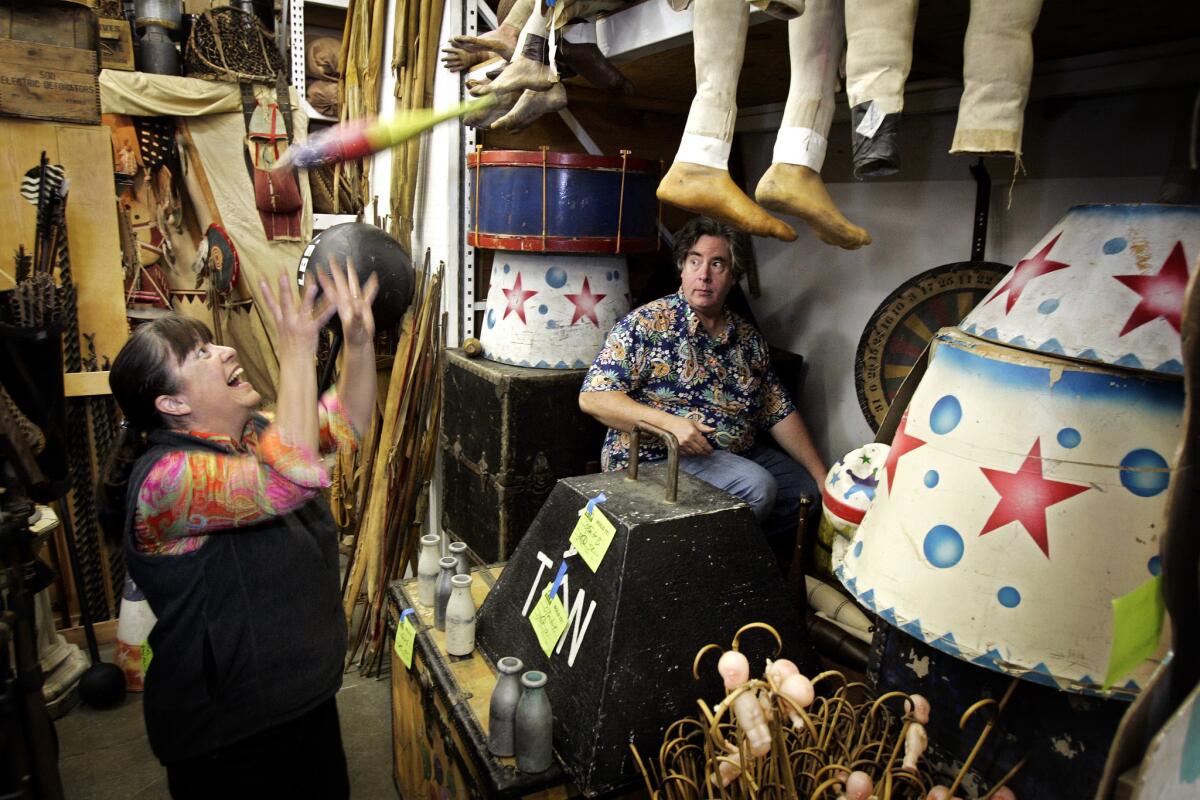 Pam Elyea catches a juggling pin thrown by her husband, Jim, while gathering props for the film "Water for Elephants" in 2010 at their store History for Hire, a prop shop specializing in period and historical items. (Ricardo DeAratanha / Los Angeles Times)