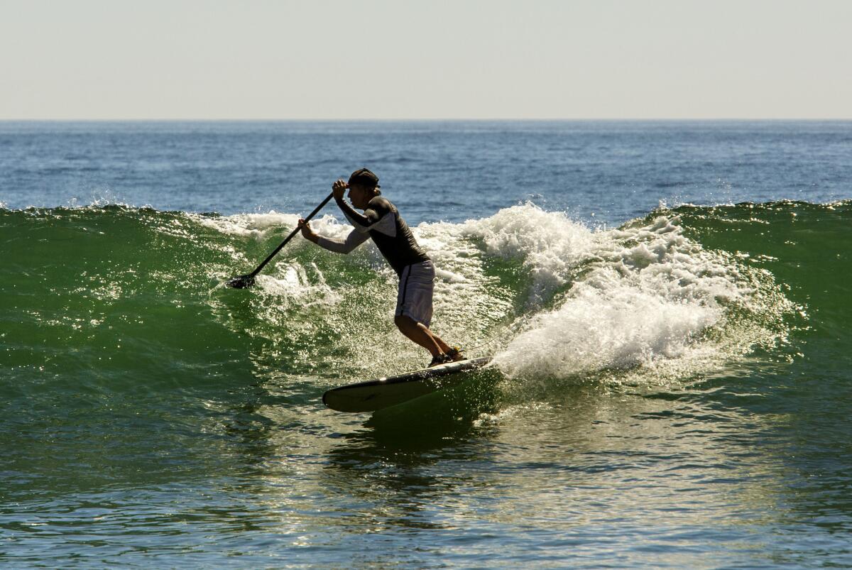 A paddleboarder rides a wave at Topanga State Beach in October 2015. February of 2016 was almost two degrees above the previous record set in 1954.