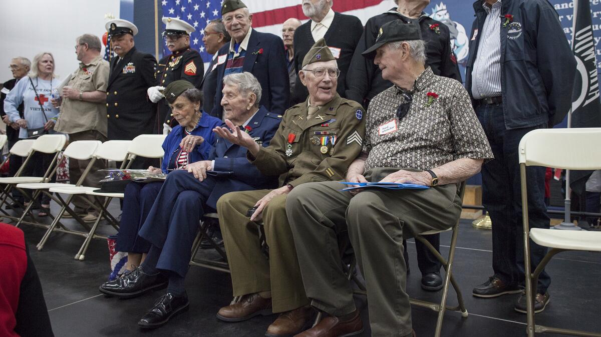 World War II veteran Dick O’Brien, 93, seated second from right, sits with fellow vets after a Living History luncheon at Corona del Mar High School on Thursday.