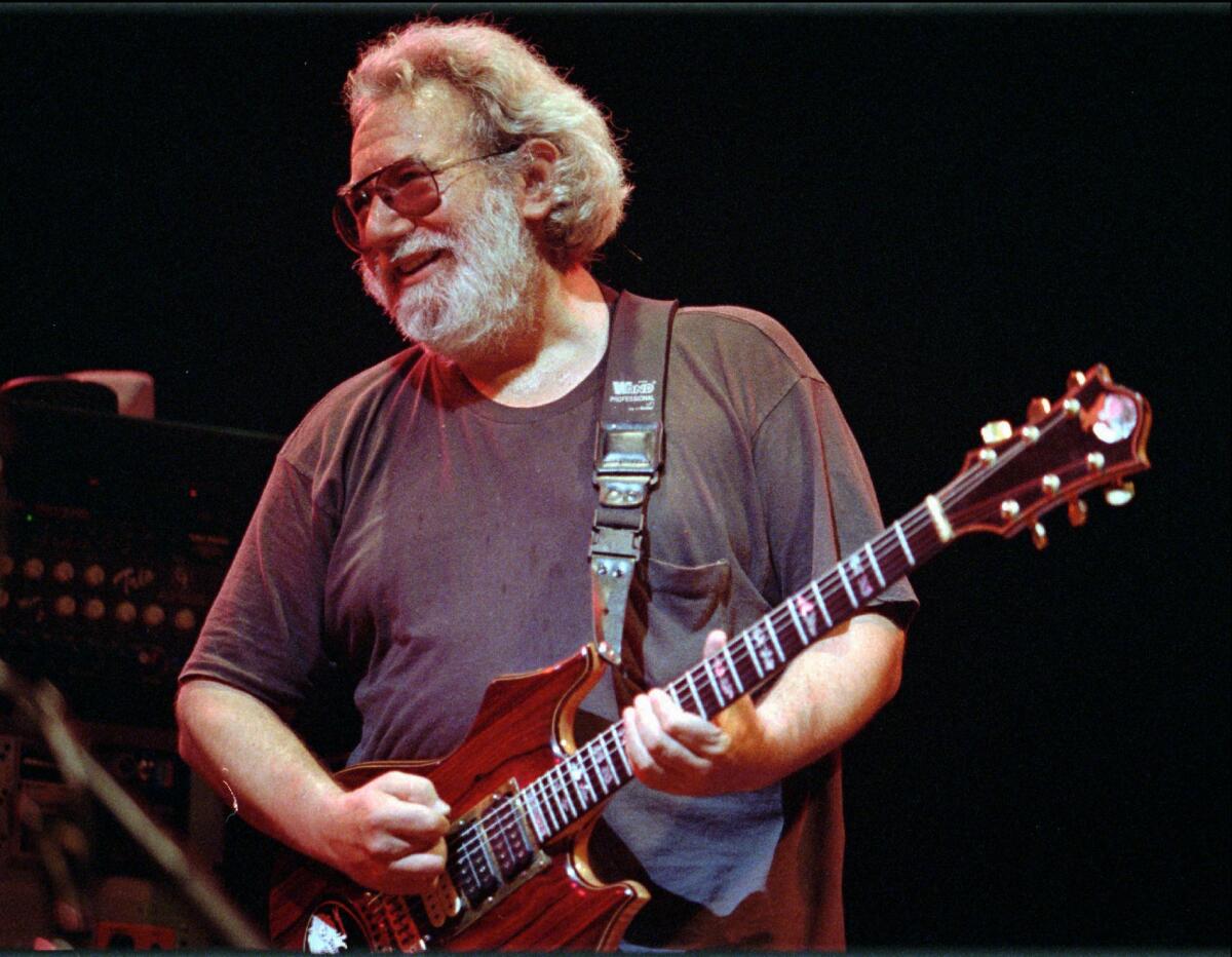  Jerry Garcia strums a guitar.