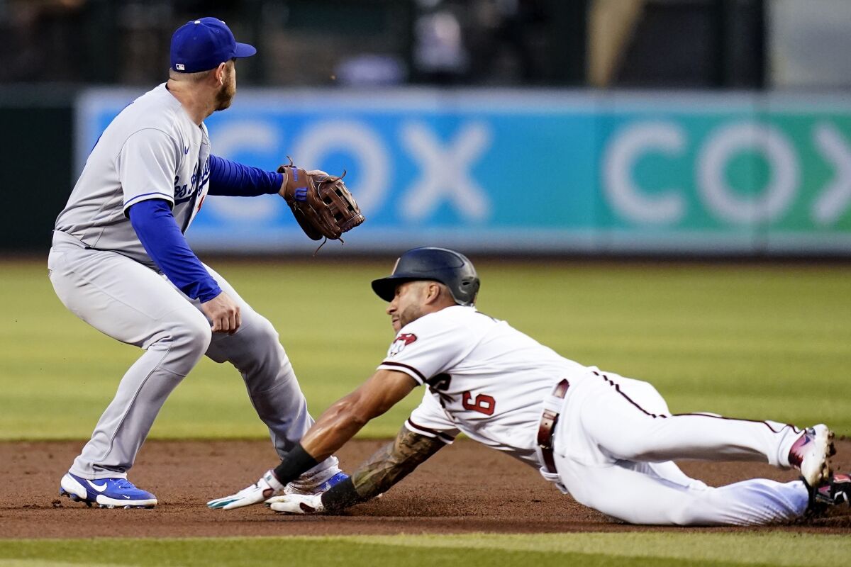 Arizona Diamondbacks' David Peralta dives into second base with a double as Dodgers third baseman Max Muncy covers.