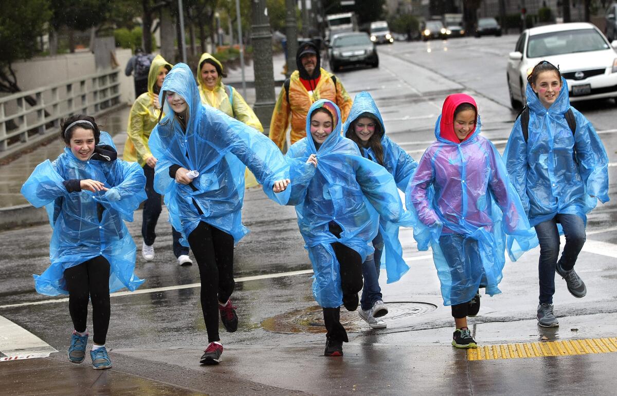 Fifth-graders from Wilbur Avenue Elementary in Tarzana run with some parents across Main Street.