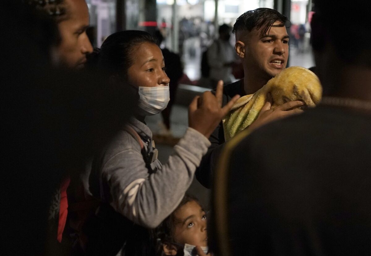 Venezuelan migrants discuss their plans as they wait for a bus to take them north.