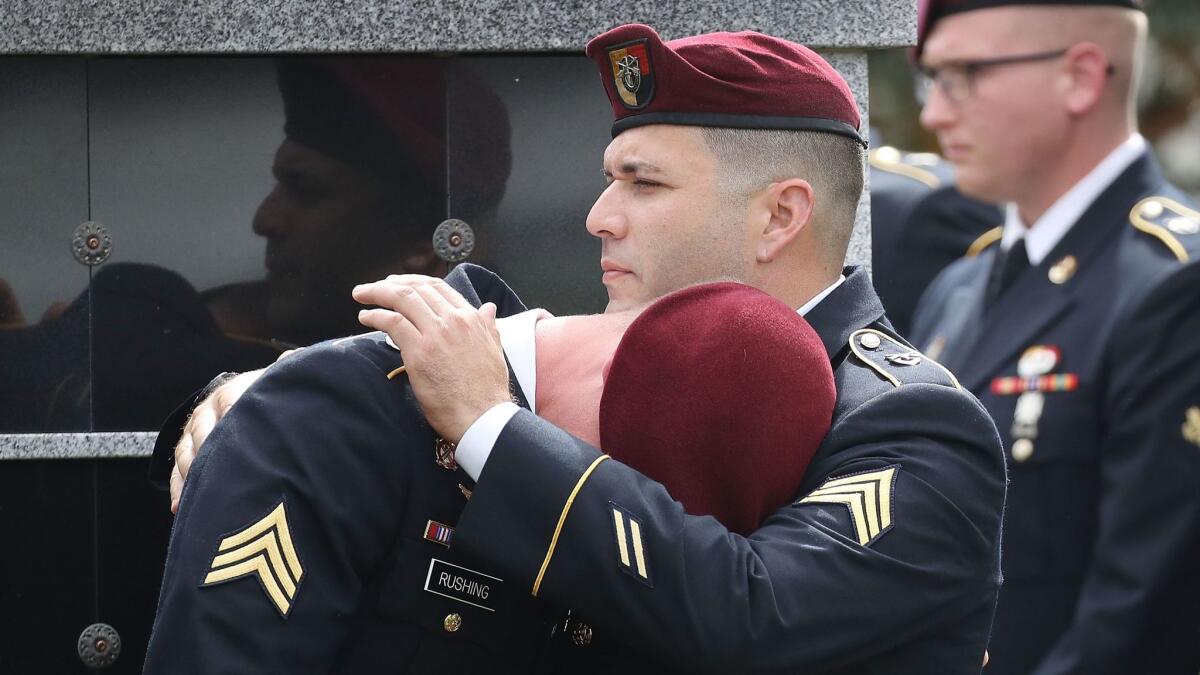 Members of Army Sgt. La David Johnson's special forces unit comfort each other at his burial service on Oct. 21, 2017, in Hollywood, Fla.