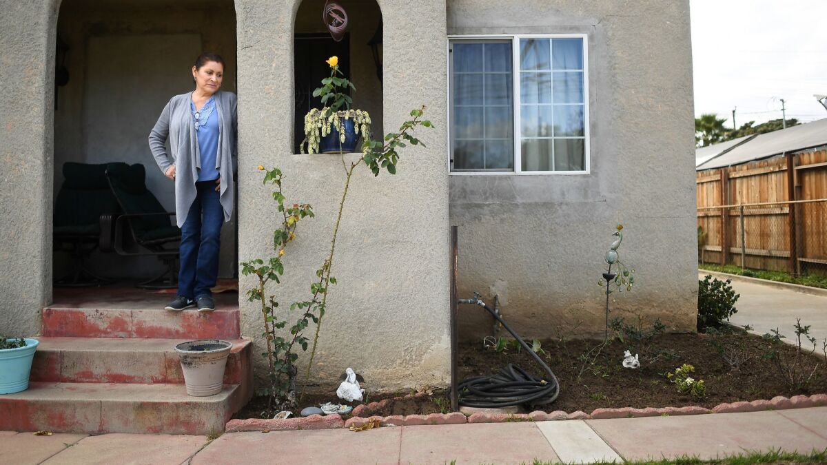 Herlinda Savarino, outside her home in East Los Angeles, is among thousands who are waiting for lead-contaminated soil to be removed. State tests two years ago found unsafe levels of lead in her yard.