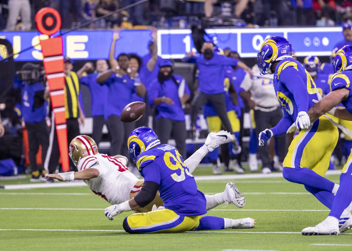 Aaron Donald tackles 49ers' Jimmy Garoppolo, whose desperation throw was intercepted to seal the Rams' win.