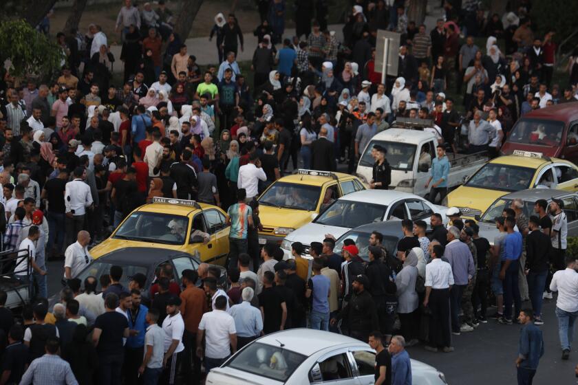 FILE - Dozens of Syrians wait at the President's Bridge in Damascus, Syria, for relatives they hope would be among those released from prison on May 3, 2022, on the second day of the Muslim Fitr holiday. The U.N. General Assembly approved Thursday, June 29, 2023, to form an independent international institution to search for the missing in Syria in both government and opposition-held areas. (AP Photo/Omar Sanadiki, File)