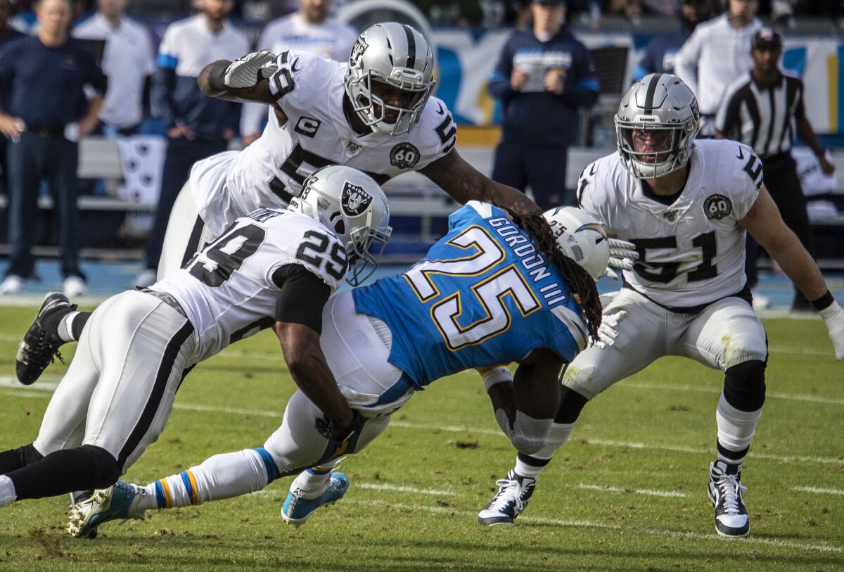 Chargers running back Melvin Gordon is tackled by Oakland Raiders safety Lamarcus Joyner.