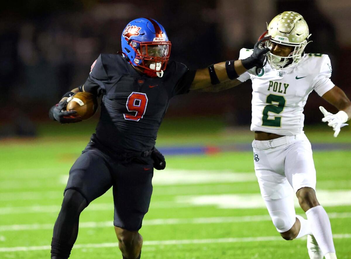 Gardena Serra's Cincere Rhaney gives a stiff-arm to Long Beach Poly's Donovan Turner.