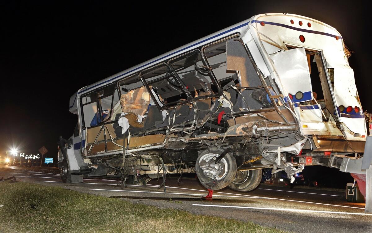 A wrecker removes the team van as Highway Patrol and emergency personnel work the scene of the crash south of Turner Falls, Okla.