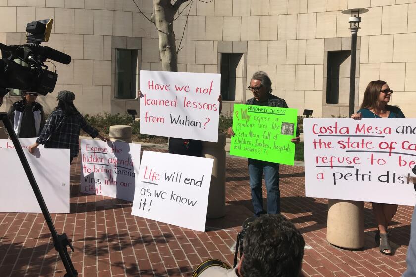 A group of protesters gathers outside the federal courthouse in Santa Ana before a hearing Monday on the possibility of sending people infected with coronavirus to Costa Mesa.