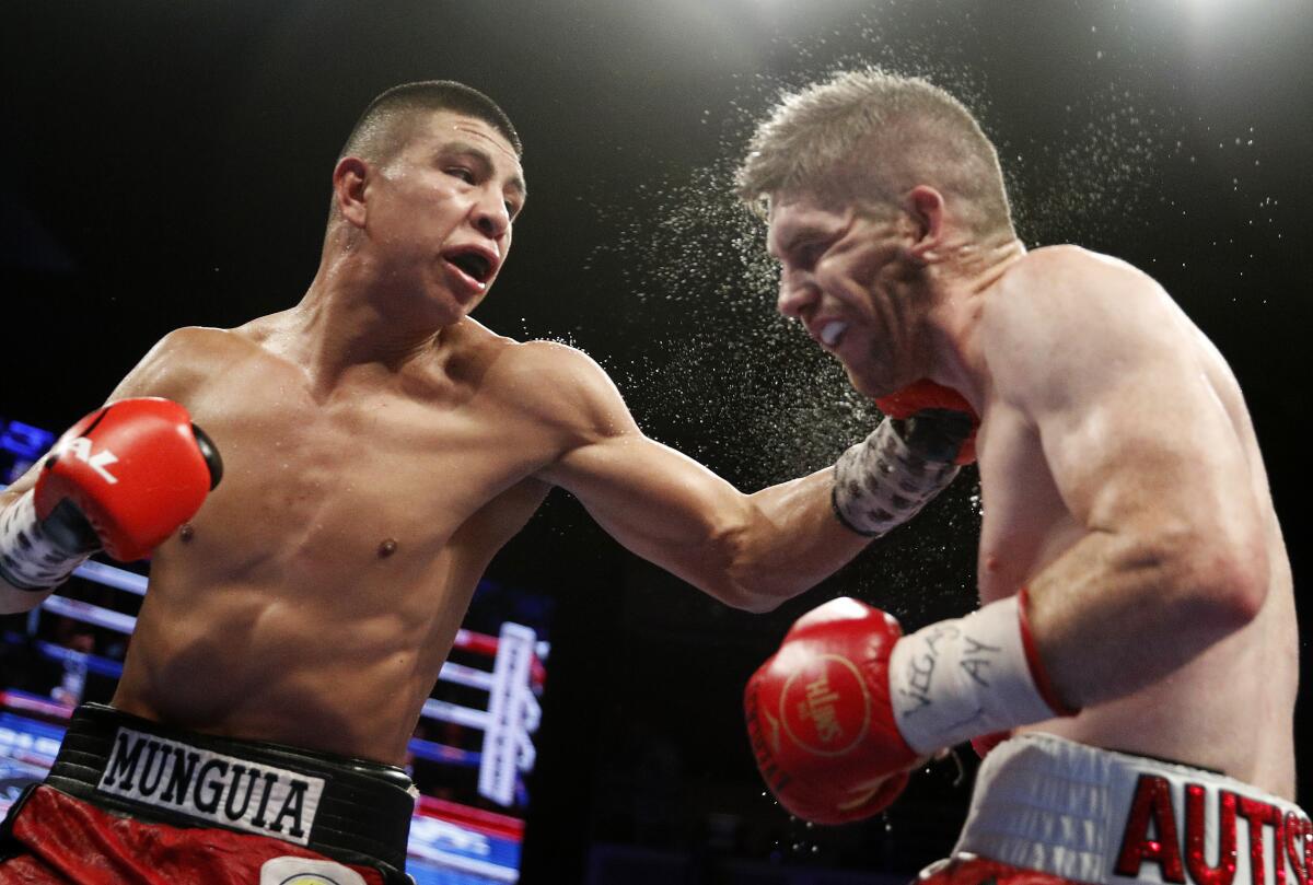 Jaime Munguia, left, lands a hard left to the head of Liam Smith during their fight in July 2018.