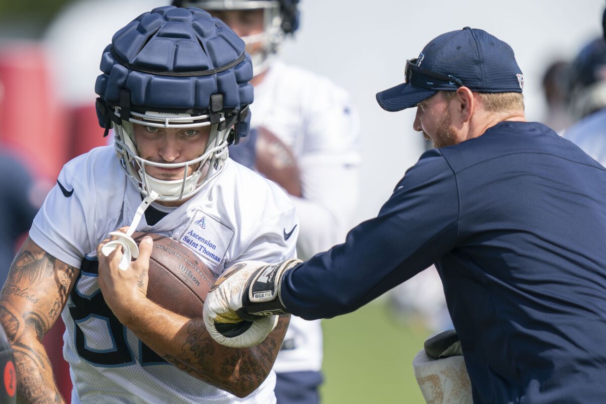 Tennessee Titans tight end Briley Moore holds on to the ball as tight ends coach Luke Steckel tries to punch it out during an NFL football training camp practice, Sunday, Aug. 14, 2022, in Nashville, Tenn. (George Walker IV/The Tennessean via AP)