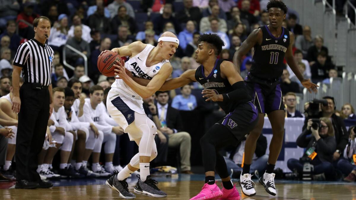 Utah State's Brock Miller, left, is pressed by Washington's Jamal Bey during the second half in the first round of the NCAA tournament on Friday in Columbus, Ohio.