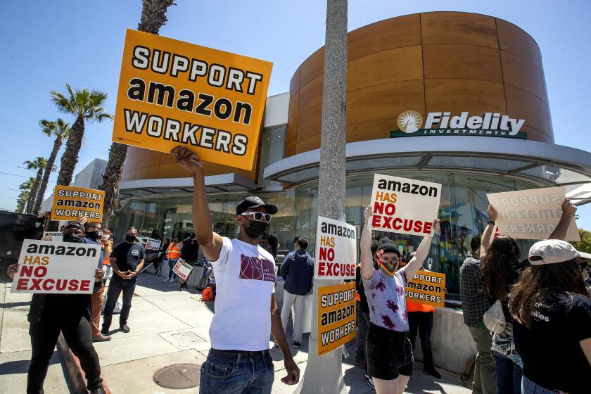 SANTA MONICA, CA - MAY 24, 2021: Ron Allen, foreground, left, a member of Art Directors Guild local 800, joins other supporters of Amazon workers protesting outside of Fidelity Investments in Santa Monica. The protest was held outside of Fidelity Investments because they are one of Amazon's largest shareholders. The protesters were demanding that Fidelity, along with four other asset management companies that they say collectively own 21% of Amazon shares, vote for a set of shareholder proposals calling for Amazon to be more accountable to workers, communities, and other stakeholders, including resolutions demanding Amazon cut ties with police and ICE, roll back anti competitive monopoly practices, reduce its carbon footprint and improve working conditions. (Mel Melcon / Los Angeles Times)